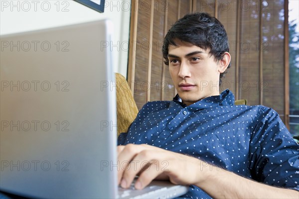 Mixed race man typing on laptop