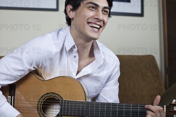 Mixed race man playing guitar