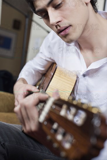 Mixed race man playing guitar