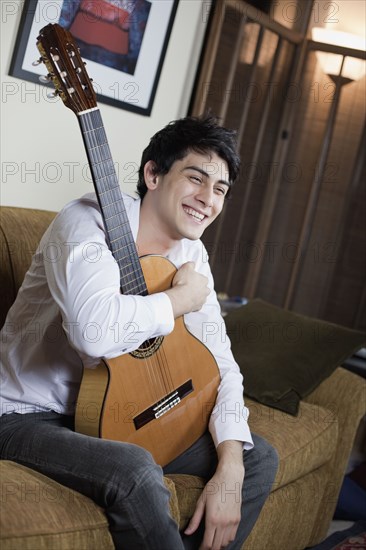 Mixed race man holding guitar