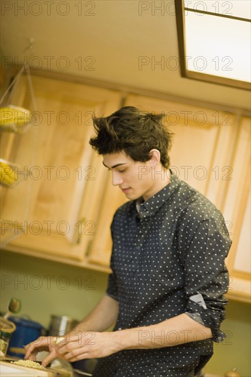 Mixed race man preparing food in kitchen