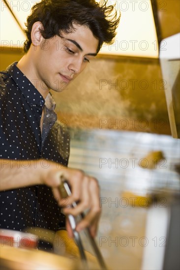 Mixed race man preparing food in kitchen