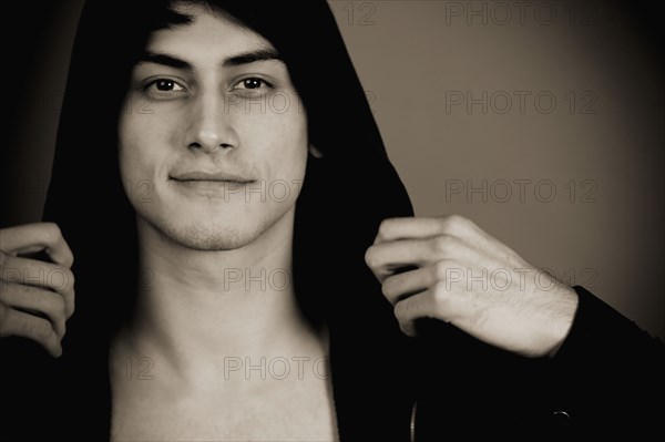 Smiling mixed race man in hooded jacket