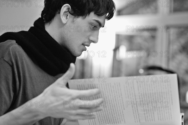 Mixed race man reading book