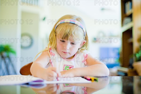 Caucasian girl drawing at table