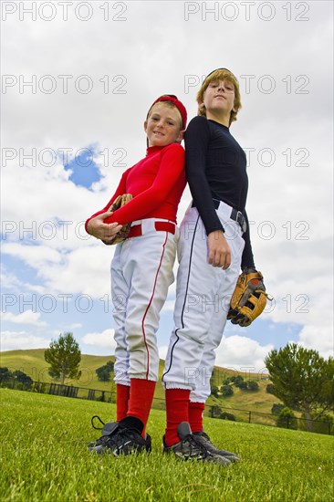 Baseball players standing back to back in field