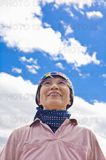 Older Japanese woman smiling outdoors