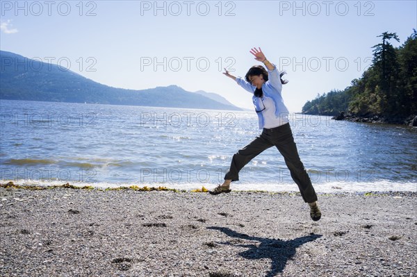 Japanese woman doing cartwheel on beach