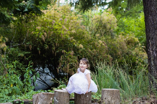 Mixed race girl balancing on logs in park