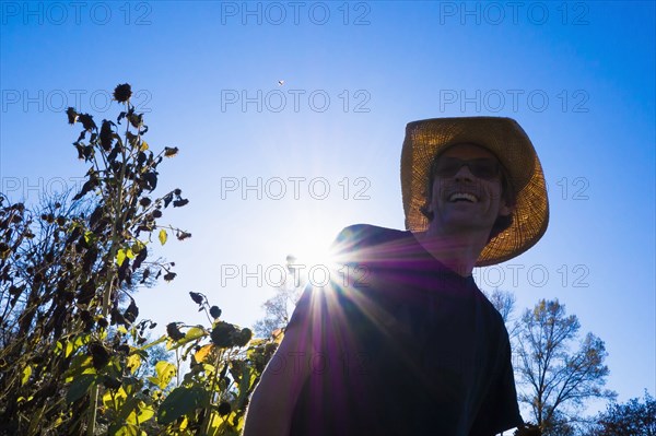 Caucasian farmer wearing straw hat under blue sky