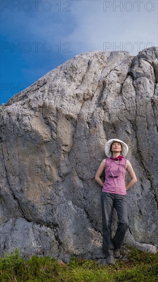 Japanese woman leaning on rock formation