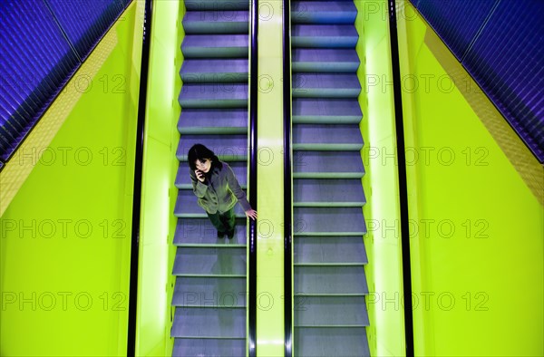 Japanese woman riding escalator