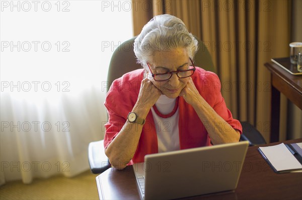 Caucasian woman using laptop at desk