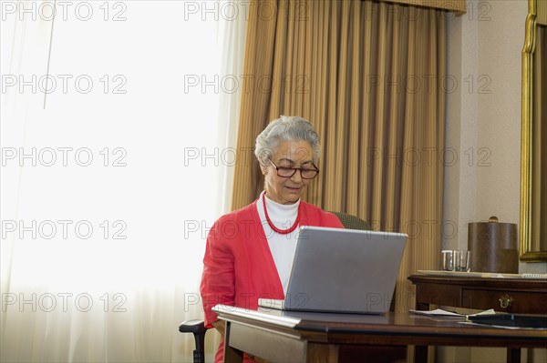 Caucasian woman using laptop at desk