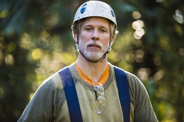 Logger wearing hat and suspenders outdoors