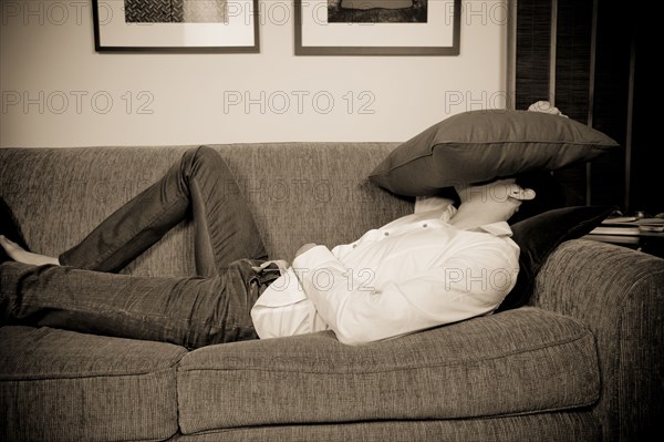 Mixed race man laying on sofa