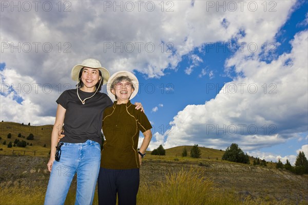 Japanese mother and daughter standing on hillside