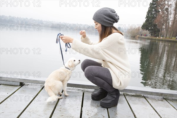 Japanese woman walking dog near lake