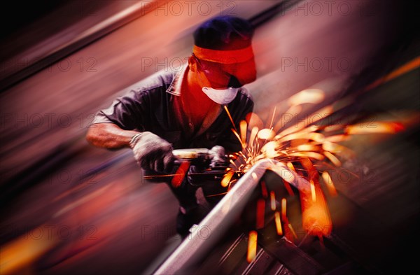 Caucasian welder working on metal pipe