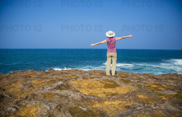 Japanese woman standing on rocky beach