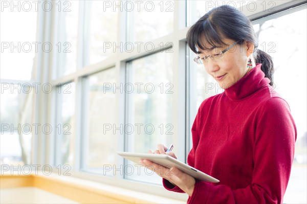 Japanese businesswoman holding pen and digital tablet