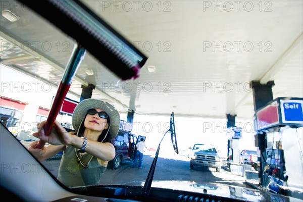 Japanese woman using squeegee on car windshield