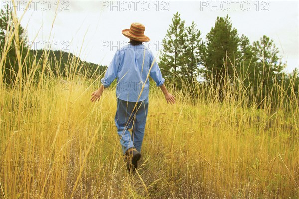 Japanese woman walking in field of tall grass