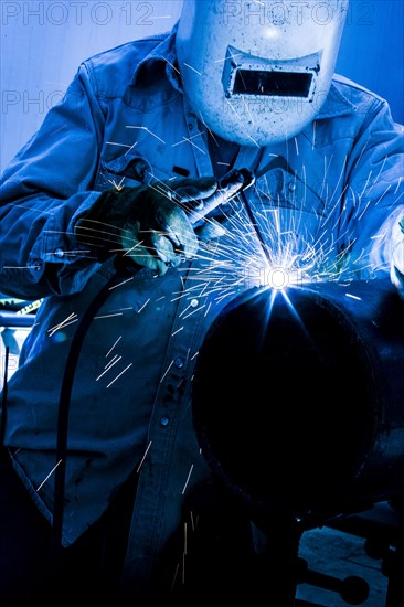 Caucasian welder working in factory