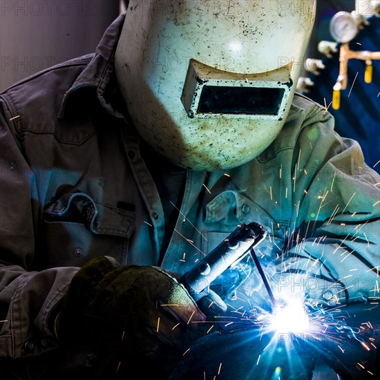 Caucasian welder working in factory