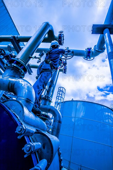 Caucasian worker turning valve at factory