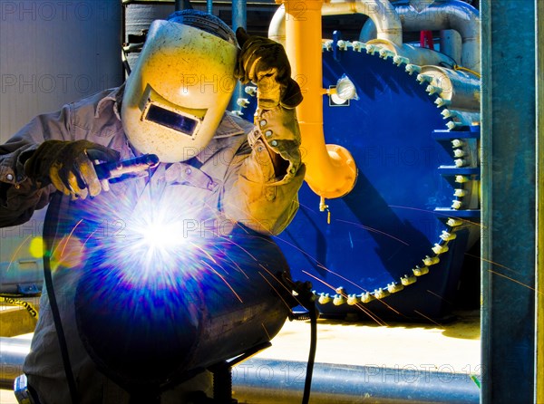 Caucasian welder working in factory