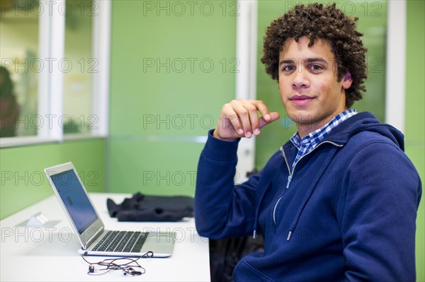 Mixed Race student using laptop in library