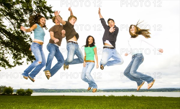 Friends jumping for joy near river