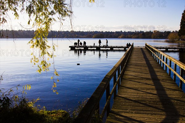 Distant people at end of dock at river