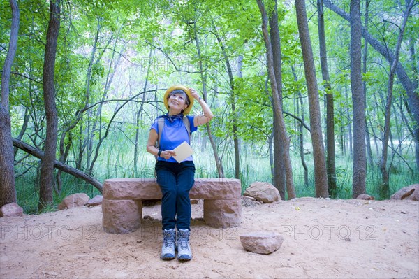 Japanese woman sitting on bench at park