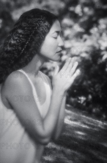 Japanese woman praying outdoors