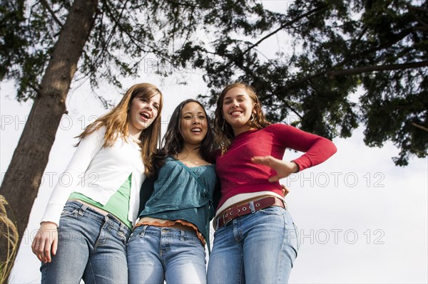 Low angle view of smiling girls near tree