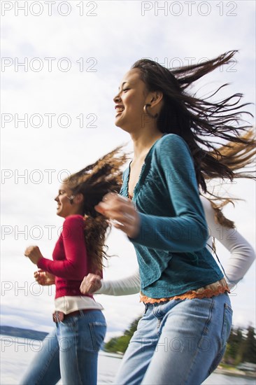 Smiling girls running on beach