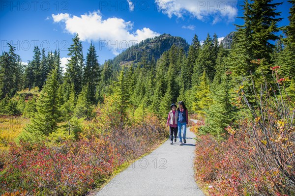 Older Japanese mother and daughter walking on nature path