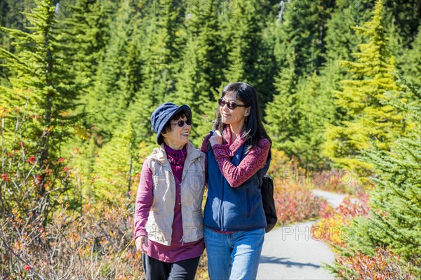 Older Japanese mother and daughter walking on nature path