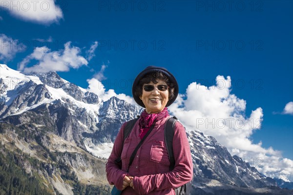 Older Japanese woman posing near mountain