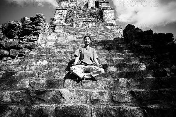 Japanese woman meditating on staircase to temple