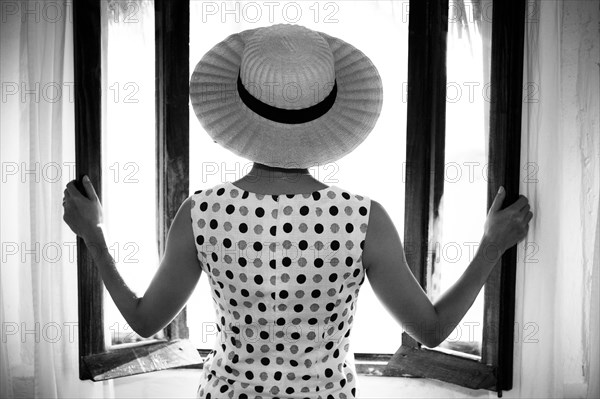 Glamorous woman opening windows