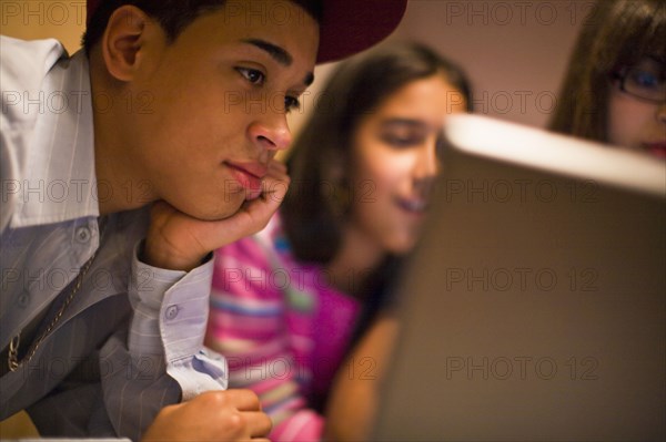 Hispanic brother and sisters using laptop