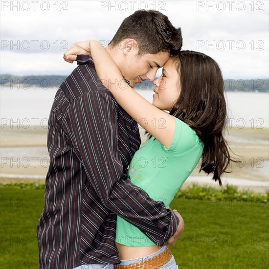 Teenage couple hugging outdoors