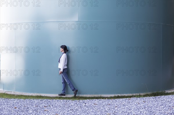 Japanese woman walking near storage tank
