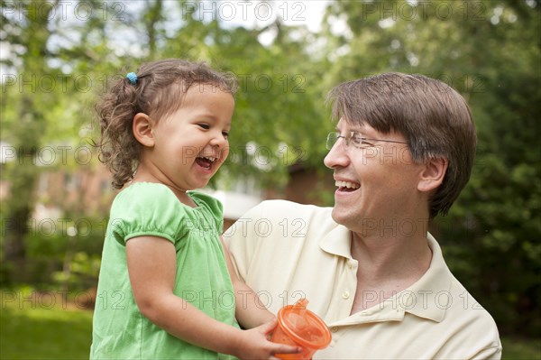 Smiling father holding daughter