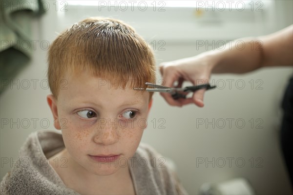 Caucasian mother giving son haircut