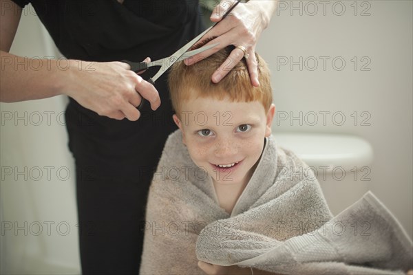 Caucasian mother giving son haircut