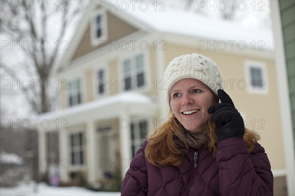 Caucasian woman using cell phone in snow